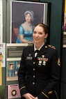 Army Staff Sgt. Trisha Emmons poses for a photo near a display of Jane Austen in the Green Mountain Armory on Camp Johnson, Vermont, March 18, 2021. Emmons, a human resources NCO with the Vermont Army National Guard's Medical Readiness Detachment, Garrison Support Command, was one of several Guardswomen who facilitated an online book reading and showcase of Guard uniforms and equipment for children at a local day care center. (U.S. Army National Guard photo by Don Branum)