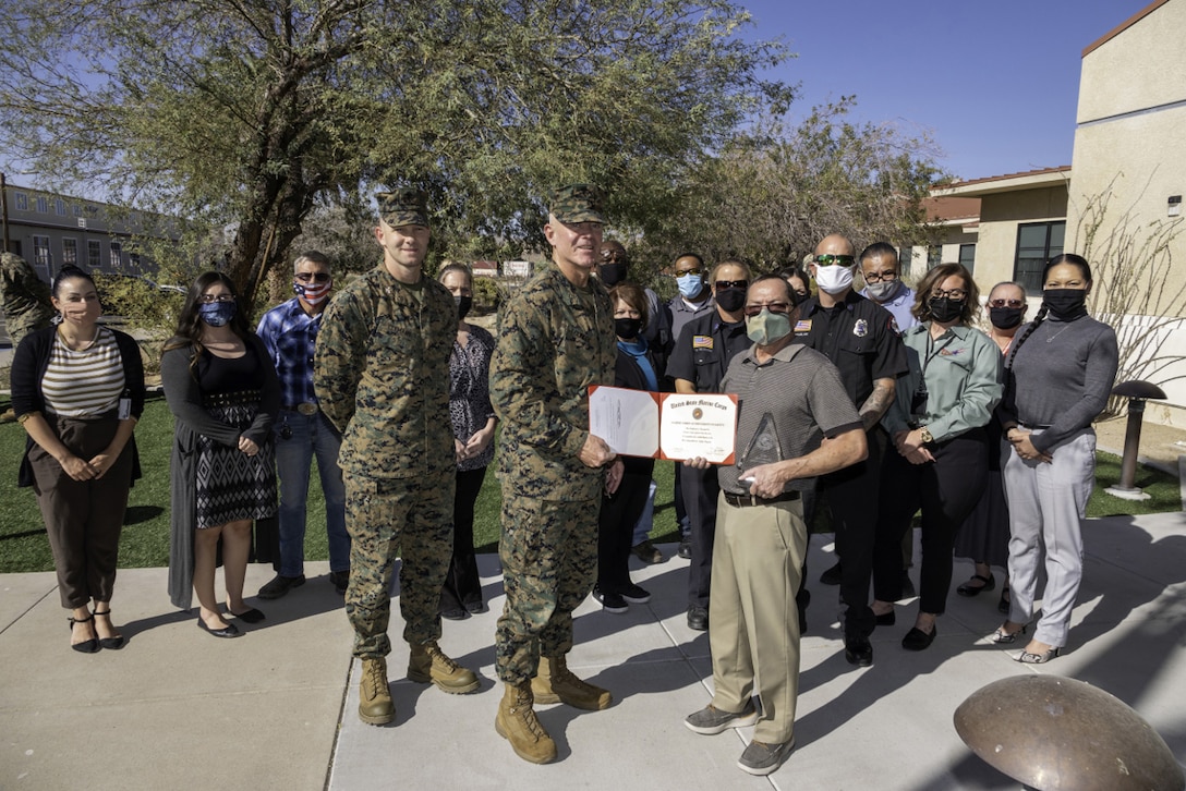 Brigadier General Daniel B. Conley, Commanding General, Marine Corps Installations West, Marine Corps Base Camp Pendleton, presents Ray Aquilar, Installation Safety Officer, and the entire Safety Division staff with the Marine Corps Ground Safety Award for the base’s outstanding safety record for fiscal year 2019, during a ceremony held aboard marine Corps Logistics Base Barstow, California, November 4, 2020. The base has earned the award for the second consecutive year for fiscal year 2020.
