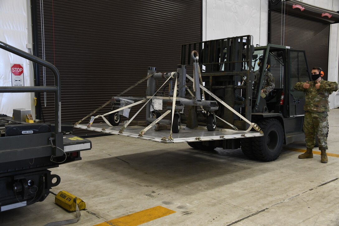 Airmen from the 92nd Logistics Readiness Squadron place a pallet of equipment onto a K-Loader trailer on Fairchild Air Force Base, Washington, March 3, 2021. The “Dawgbone” creates a more efficient way for Airmen to load and offload equipment from K-Loader trailers. (U.S. Air Force photo by Senior Airman Breanne White)