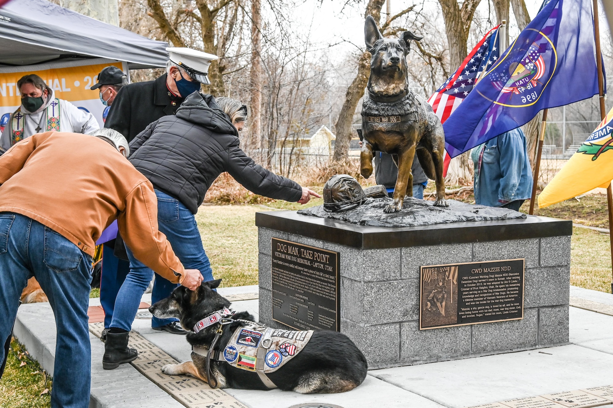 Community members pet retired Contract Working Dog Mazzie, who sits in front of the Vietnam Veterans War Dog Memorial, which was modeled after him, during the dedication ceremony Mar. 13, 2021 in Layton, Utah. The memorial is a monument honoring war dogs that served during a time when they were forgotton. (U.S. Air Force photo by Cynthia Griggs)