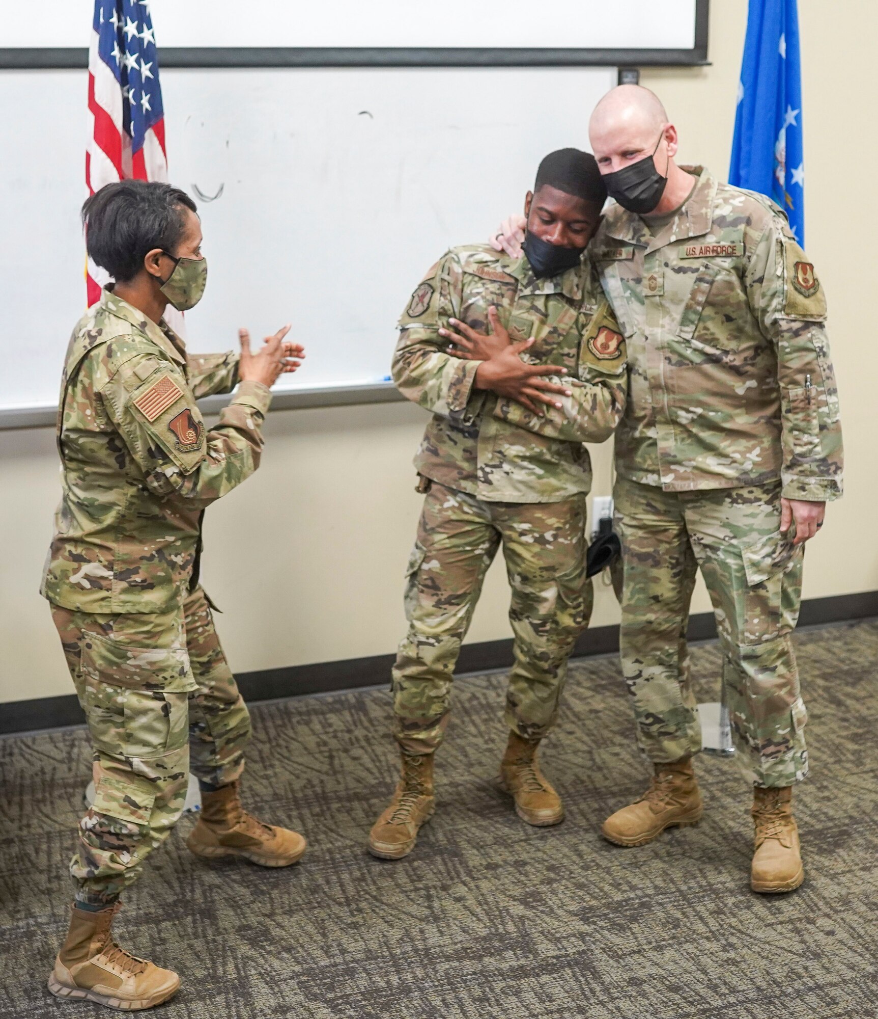 Chief Master Sgt. Christopher Walker, 75th Air Base Wing command chief, embraces Airman First Class Kamari Johnson, a defender with the 75th Security Forces Squadron, to congratulate Johnson’s acceptance to the U.S. Air Force Academy Preparatory School while Col. Jenise Carroll, 75th Air Base Wing commander, looks on March 18, 2021, at Hill Air Force Base, Utah.