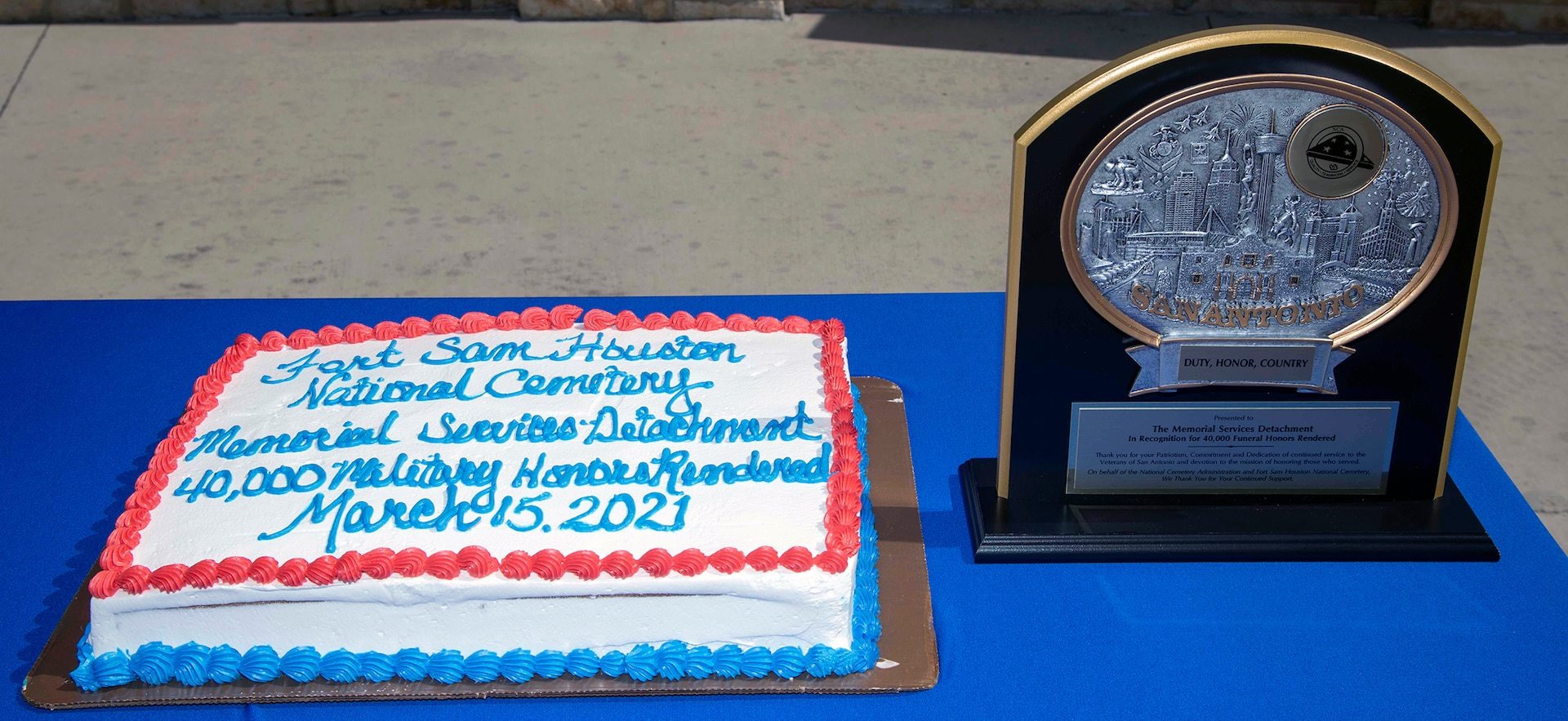 A cake and plaque sit on a table during a ceremony at the Fort Sam Houston National Cemetery in San Antonio March 15. The plaque was given to the detachment to commemorate their 40,000th funeral service.
