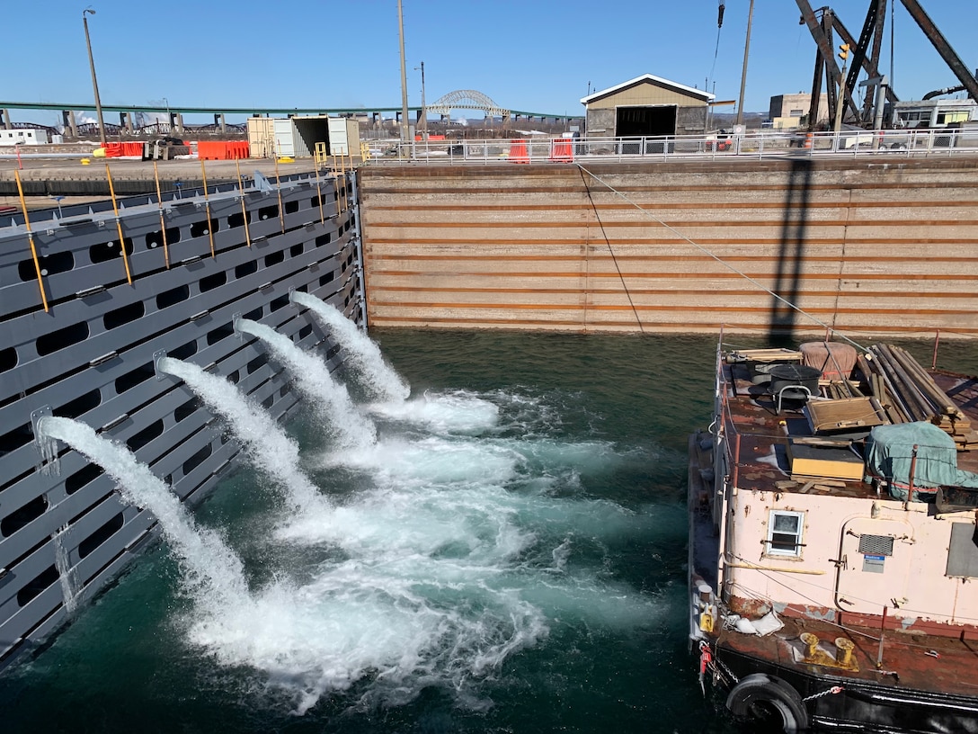 The U.S. Army Corps of Engineers, Detroit District prepares to open the Soo Locks in Sault Ste. Marie, Mich., on March 15, 2021. To prepare the Lock for the opening of the shipping season, workers began watering the lock by opening valves in stop logs placed to hold back the St. Marys River. (U.S. Army photo by Carrie Fox)