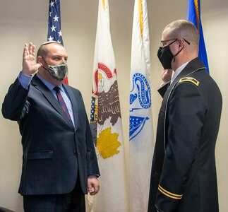 Rabbi Aaron Melman, of Northbrook, Illinois, recites the oath of commissioning as a captain in the Illinois Army National Guard administered by Chaplain (Col.) Stephen Foster, of Riverton, Illinois, Illinois National Guard State Chaplain, during a ceremony March 17 at Camp Lincoln, Springfield, Illinois.