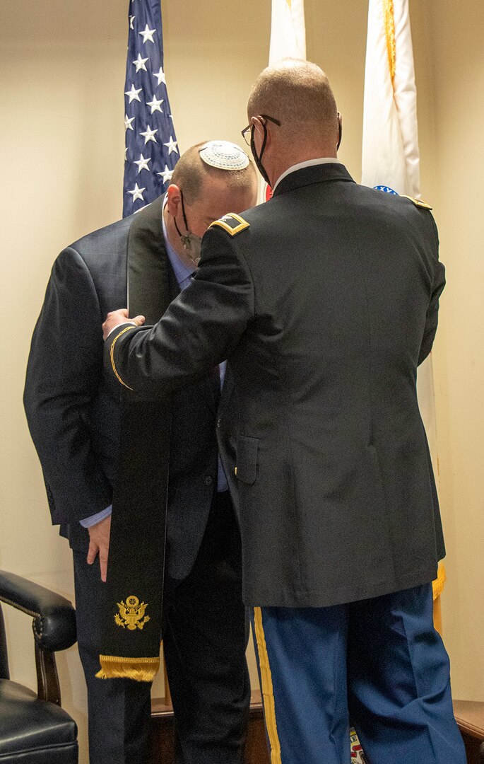Illinois National Guard State Chaplain (Col.) Steve Foster, of Riverton, Illinois, presents newly commissioned Illinois Army National Guard Jewish Chaplain (Capt.) Aaron Melman, of Northbrook, Illinois, with the Chaplain’s Stole during a ceremony March 17 at Camp Lincoln, Springfield, Illinois.
