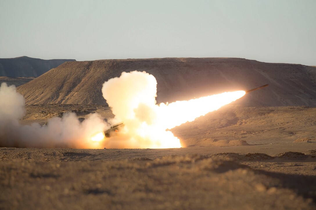 Marines fire a rocket in a field.