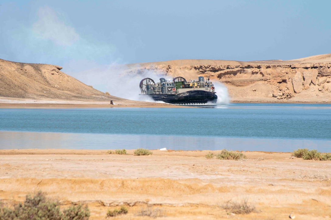 A Navy air-cushioned landing craft travels through waters.