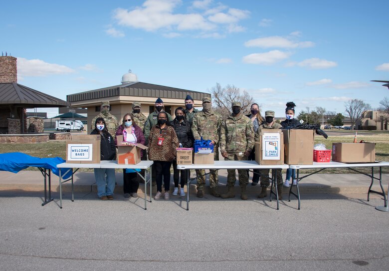 Members of the Armed Services YMCA (ASYMCA) of Altus Air Force Base (AFB), First Sergeants Council, Exceptional Family Member Program, Airman and Family Readiness Center, and the Mental Health Clinic pose for a photo during the ASYMCA open house drive-thru event at Altus AFB, Oklahoma, March 18, 2021. During the event, volunteers handed out welcome bags and brochures with information about the programs ASYMCA offers.(U.S. Air Force photo by Airman 1st Class Amanda Lovelace)