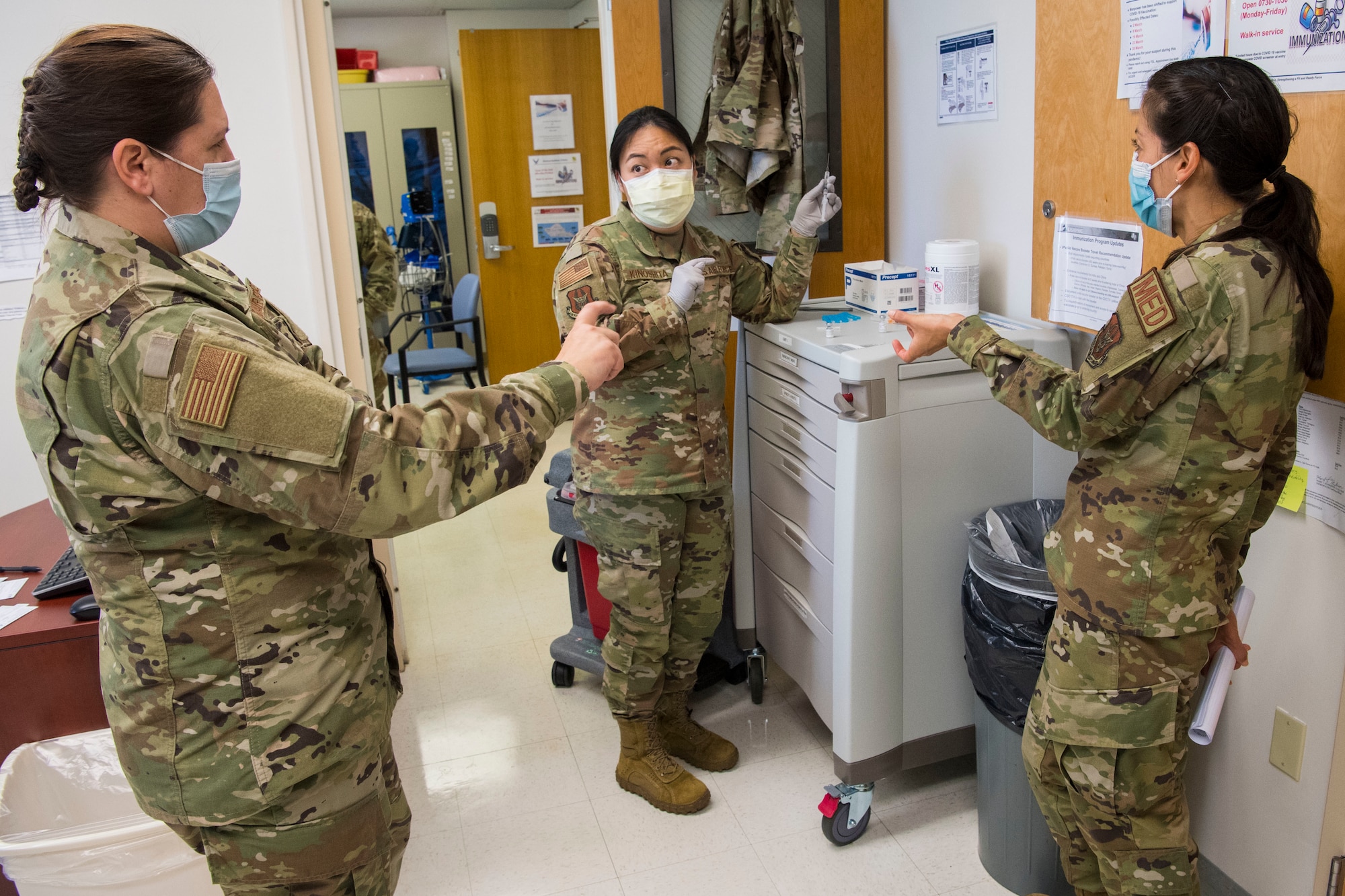 U.S Air Force 1st Lt. Rylyn Kinoshita with the 624th Aeromedical Staging Squadron instructs Capt. Kathleen Page and 1st Lt. Elizabeth Kaczmar in mixing the COVID-19 vaccine at Joint Base Pearl Harbor-Hickam, Hawaii, March 7, 2021, during the Unit Training Assembly.