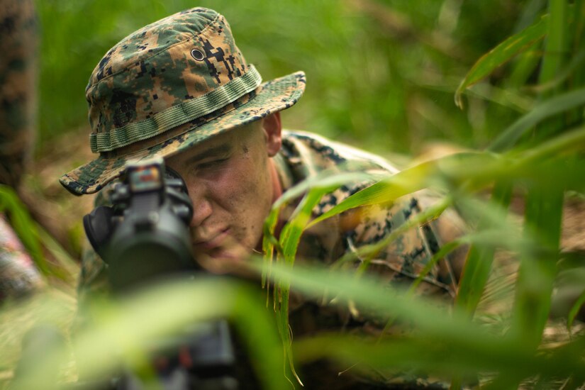 U.S. Marine Corps Lance Cpl. Clayton Takacs, a combat engineer with 3d Battalion, 8th Marine Regiment, 3d Marine Division, examines his sector of fire during Castaway 21.1 at Ie Shima, Okinawa, Japan, March 12, 2021. The exercise demonstrated the Marine Corps’ ability to integrate with the joint force to seize and defend key maritime terrain, provide low-signature sustainment, and execute long-range precision fires in support of naval operations from an expeditionary advanced base. Takacs is a native of Orwell, Ohio.