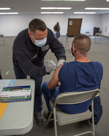 Kenneth Lyon, firefighter paramedic with Fire and Emergency Services, administers the first dose of Moderna COVID-19 vaccine to base personnel at Production Plant Barstow, Marine Depot Maintenance Command on the Yermo Annex aboard Marine Corps Logistics Base Barstow, California, March 3. The Moderna version of the vaccine requires two doses, 28 days apart. The first dose offers over 60 percent immunity and introduces the immune system to the outer shell of the virus and typically has little to no side effects other than a sore arm. The second dose is a heavier priming of the immune system as the immune system recognizes the outer shell of the virus faster and provides a robust response and over 90 percent immunity. Some recipients report exhaustion, fever and body aches for a couple of days after the second dose, which is normal.