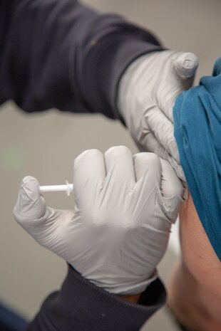 Kenneth Lyon, firefighter paramedic with Fire and Emergency Services, administers dose 1 of the two-dose Moderna COVID-19 vaccination to base personnel at Production Plant Barstow, Marine Depot Maintenance Command, at the Yermo Annex aboard Marine Corps Logistics Base Barstow, California, March 3.