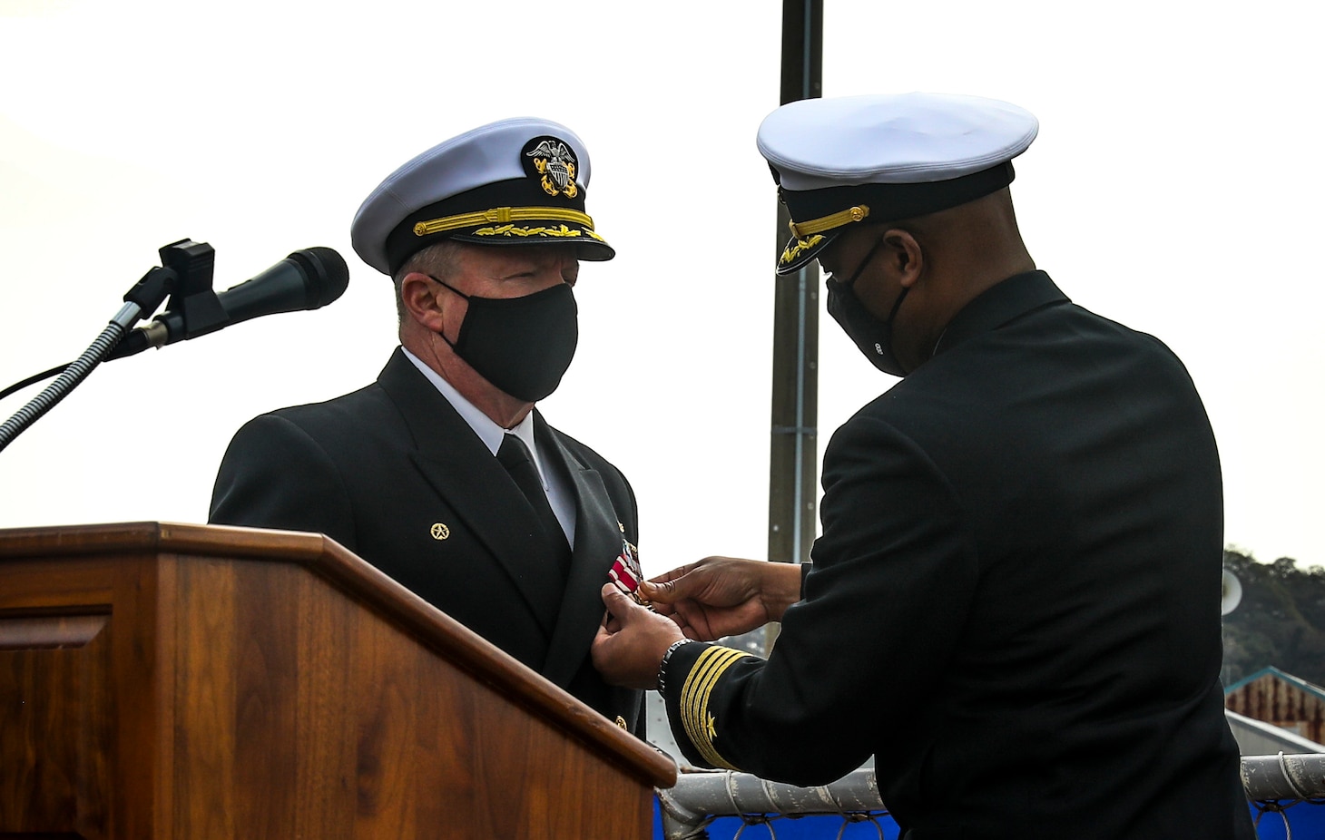 YOKOSUKA, Japan (March 19, 2021) Cmdr. Todd Penrod receives end of tour award from Capt. Walter Mainor during a change of command ceremony aboard the Arleigh-Burke class guided-missile destroyer USS Mustin (DDG 89) while in port at Naval Base Yokosuka. (US Navy photo by Mass Communication Specialist 3rd Class Arthur Rosen)