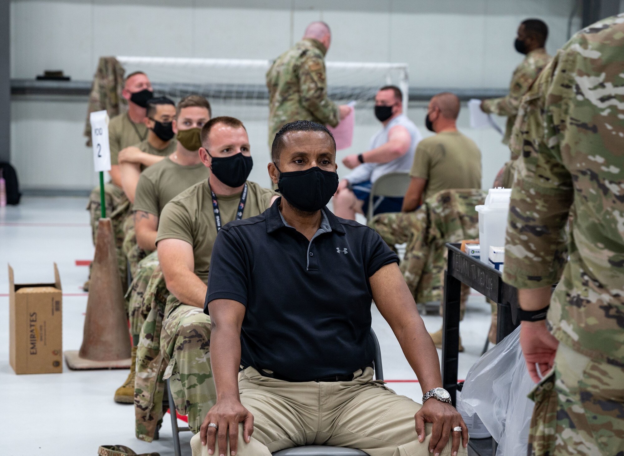 Members from the 380th Air Expeditionary Wing prepare to receive the Johnson & Johnson COVID-19 vaccine