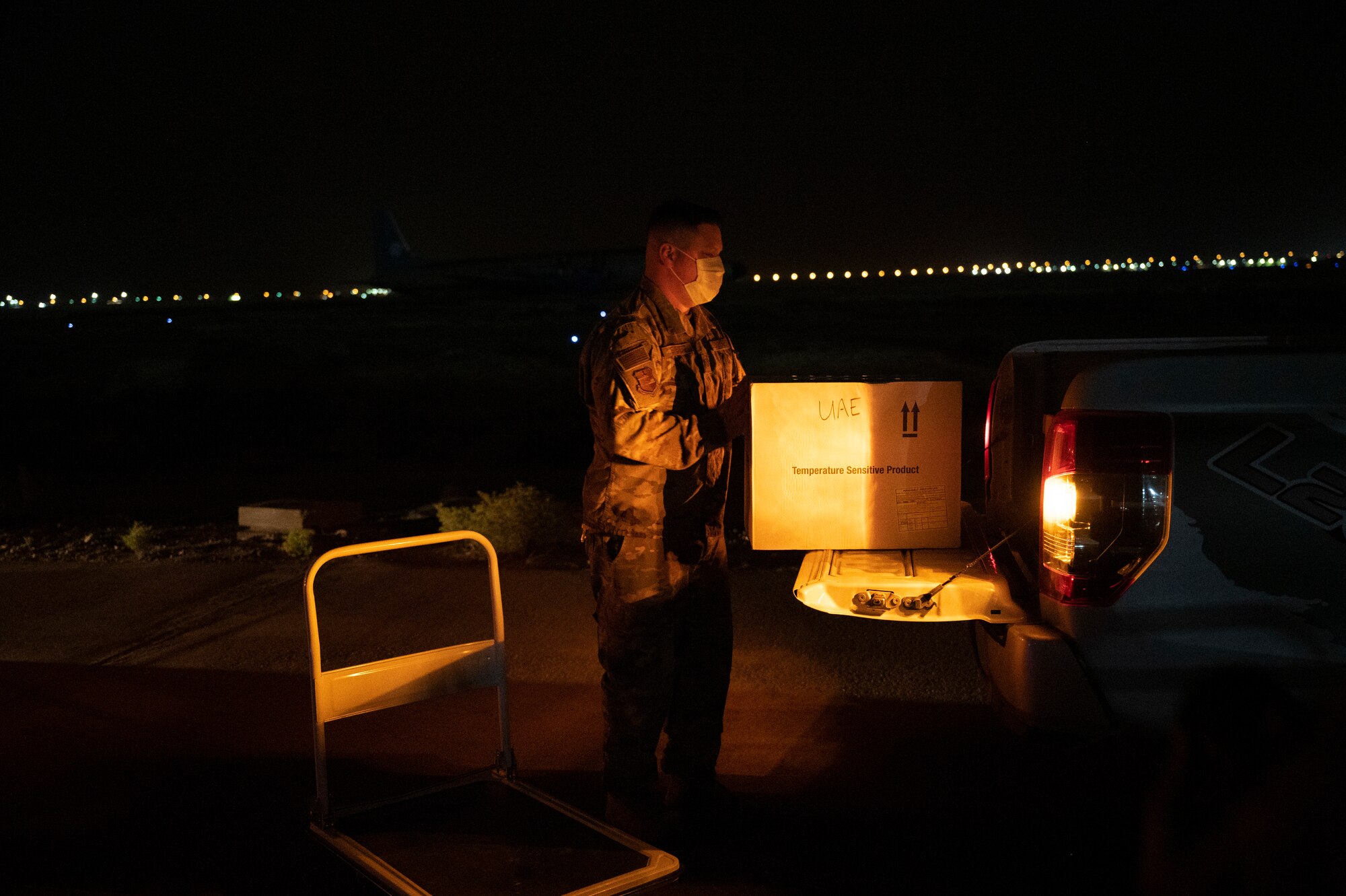 Tech. Sgt. Justin Everett loads COVID-19 vaccines onto a truck