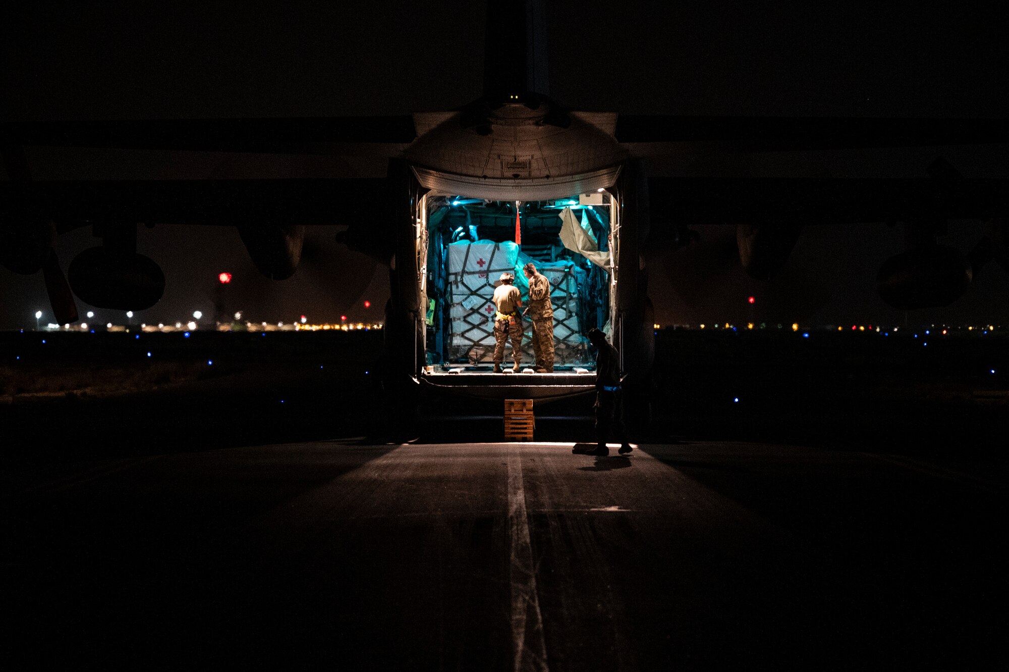 Airmen unload COVID-19 vaccines from a C-130 Hercules