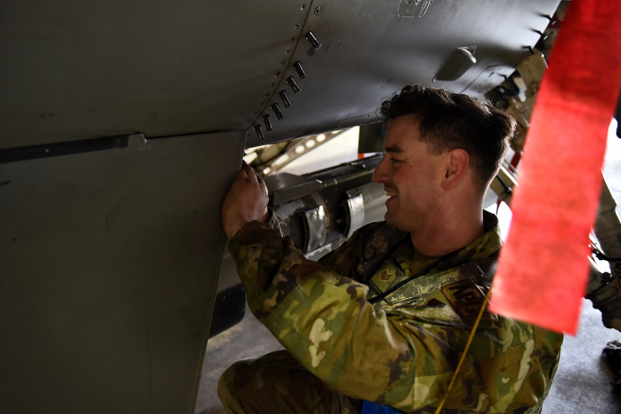 Staff Sgt. Ashley Mounts, 8th Aircraft Maintenance Squadron dedicated crew chief, tacks a panel on an F-16 Fighting Falcon for an engine run at Kunsan Air Base, Republic of Korea, March 21, 2021. Crew chiefs inspect, service, clean, and fix aircraft to ensure mission readiness. (U.S. Air Force photo by Senior Airman Suzie Plotnikov)