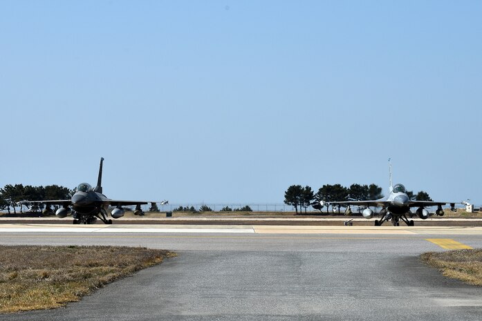 Two F-16 Fighting Falcons park on the flightline at Kunsan Air Base, Republic of Korea, March 22, 2021. The F-16 Fighting Falcon is a compact, multi-role fighter aircraft that is highly maneuverable in air-to-air combat and air-to-surface attack. (U.S. Air Force photo by Senior Airman Suzie Plotnikov)
