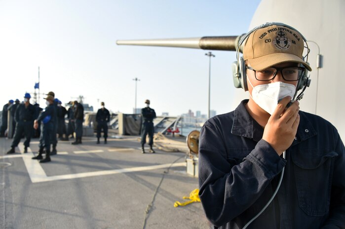 Seaman Dakota Golden, assigned to guided-missile cruiser USS Philippine Sea (CG 58), communicates with the bridge watch team during a sea and anchor detail prior to the ship departing from Manama, Bahrain, March 21. Philippine Sea is deployed to the U.S.  5th Fleet area of operations in support of naval operations to ensure maritime stability and security in the Central Region, connecting the Mediterranean and Pacific through the western Indian Ocean and three critical chokepoints to the free flow of global commerce.