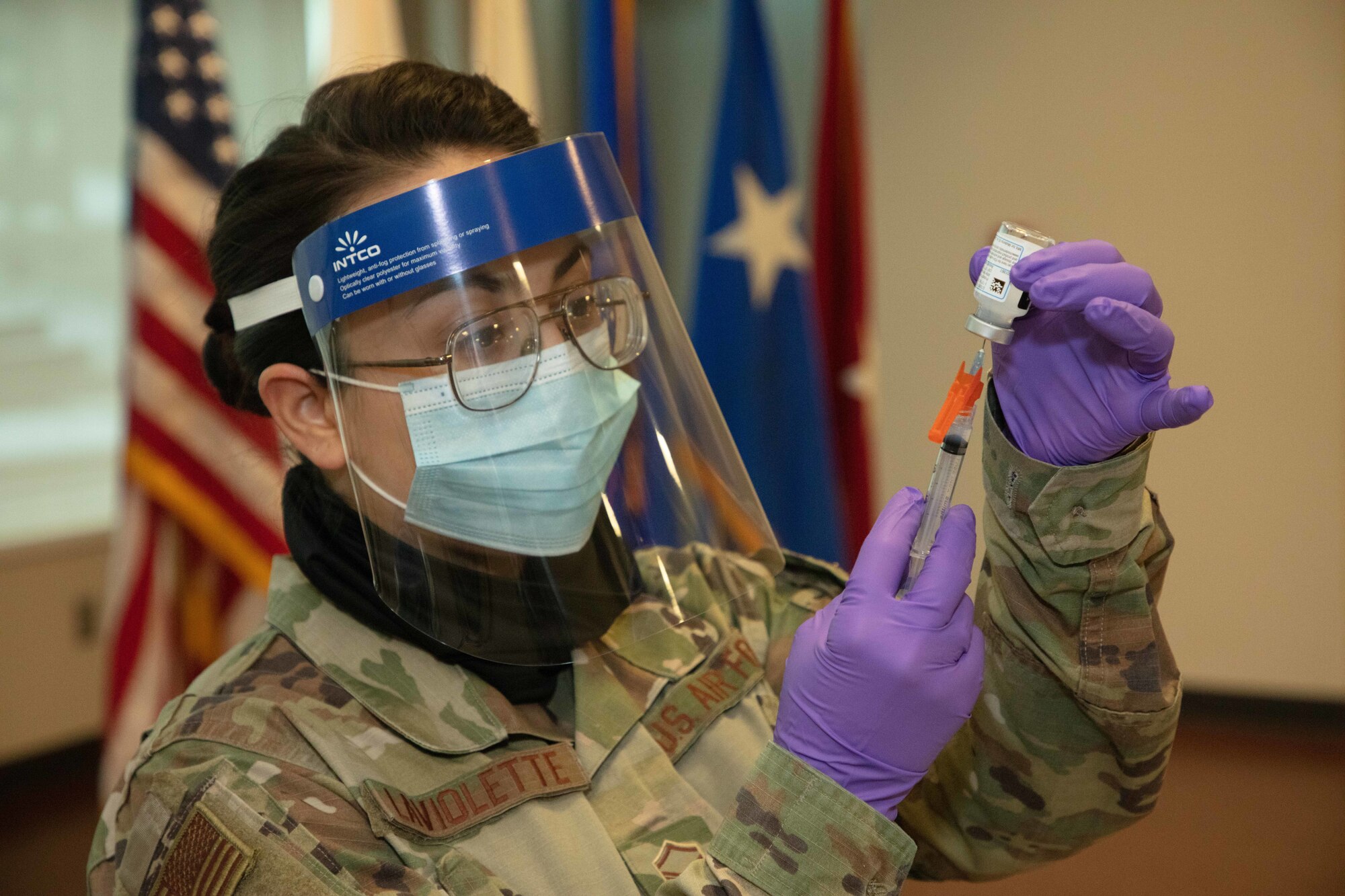 Master Sgt. Chelsea LaViolette, training and education NCOIC for the 102nd Medical Group, Otis Air Force Base, Mass., and an immunization technician for CBRNE Task Force, loads one dose of the new COVID-19 vaccine to inoculate one of the volunteers who will receive it, here, Jan. 4, 2021. The vaccine is currently available to select Soldiers and Airmen based off of risk and mission requirements, but will be available widely as supplies increase. (Massachusetts National Guard Photo by Sgt. Tricia Andriski)