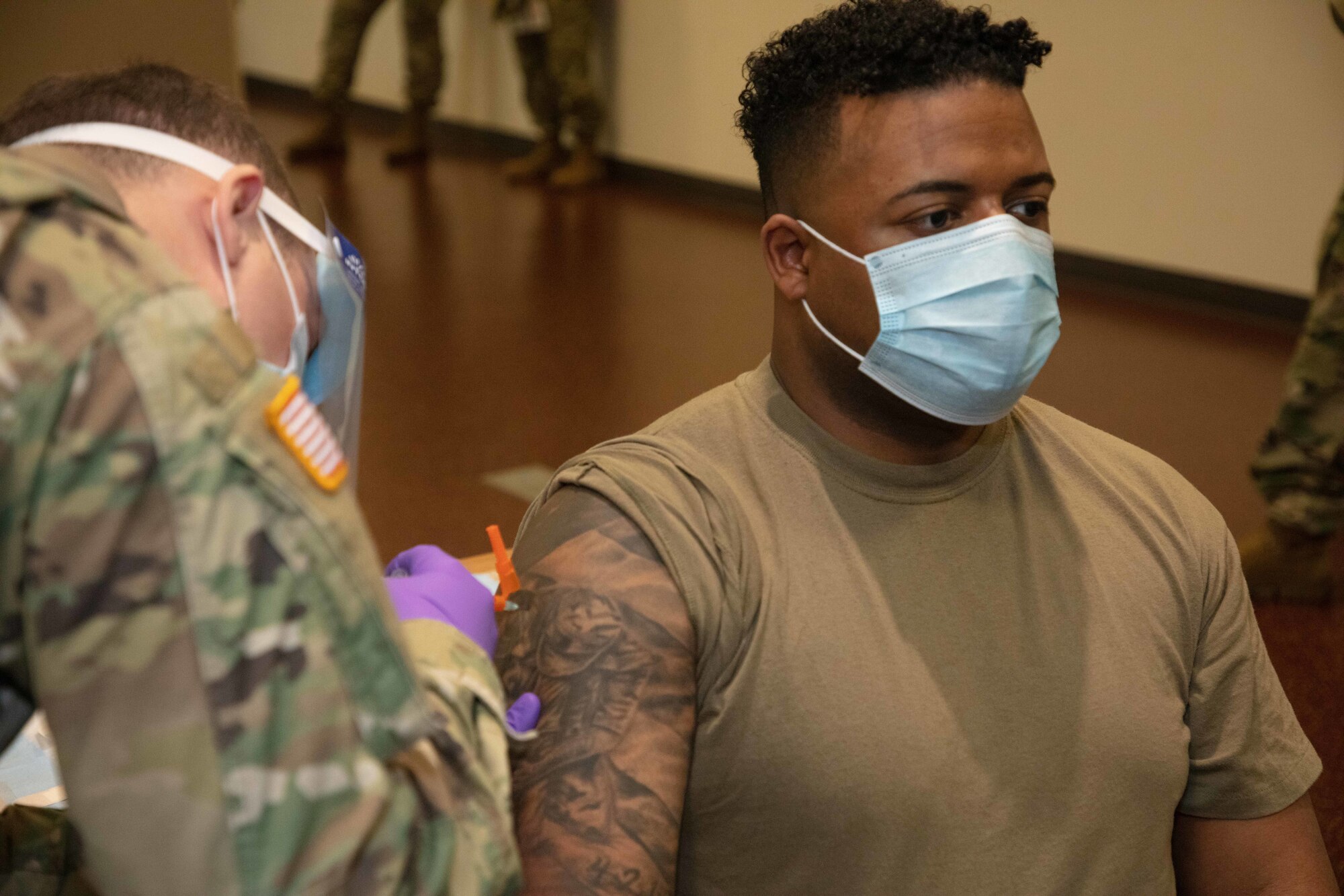 Spc. Michael Lora, a combat medic with 182nd Infantry Company, Headquarters and Headquarters Company, Melrose, Mass., volunteers to receive the vaccine for COVID-19, here, on Jan. 4, 2021. The vaccine is currently available to select Soldiers and Airmen based off of risk and mission requirements, but will be available widely as supplies increase. (Massachusetts National Guard Photo by Sgt. Tricia Andriski)