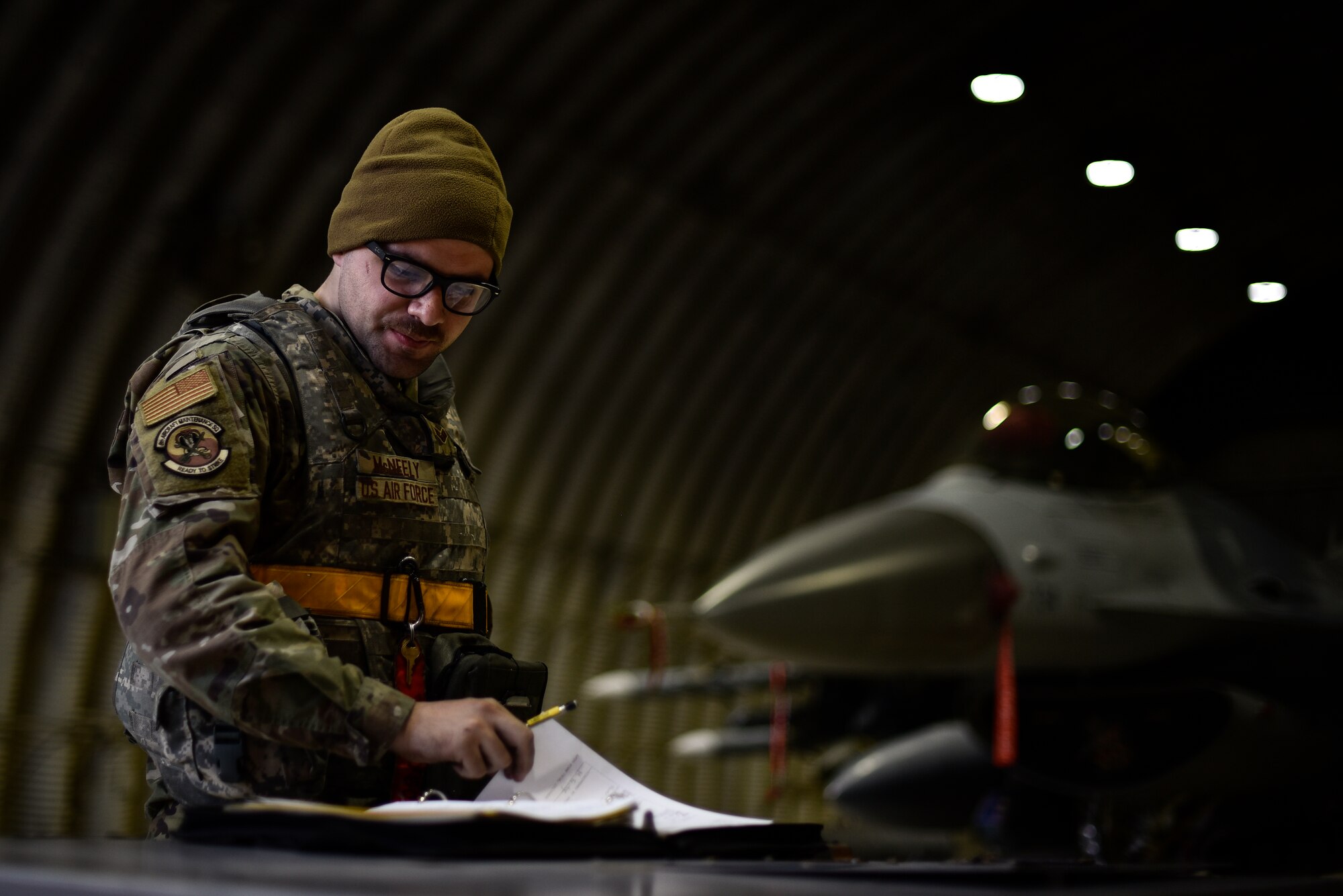 An Airman reviews forms during shift changeover.