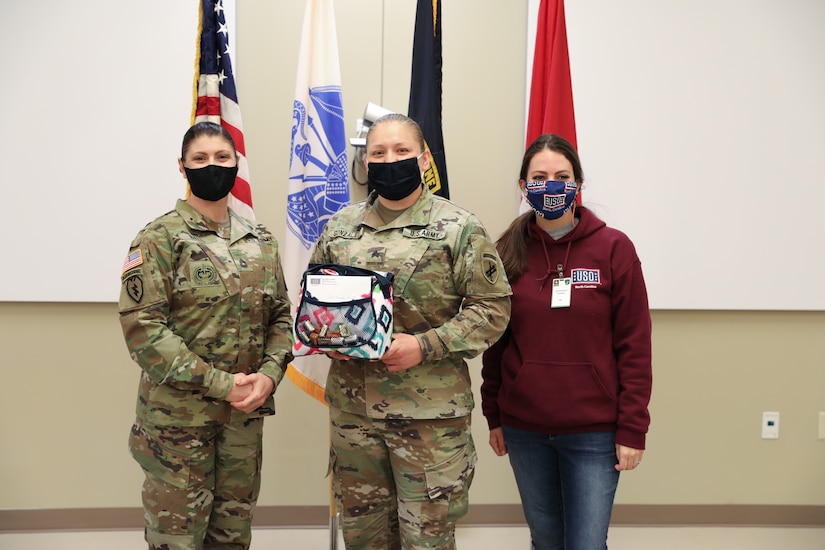 Ms. (Sgt. 1st Class) Kristen Bell, and Sgt. Teresa Gonzalez, 1st Civil Affairs and Psychological Operations Training Brigade, pose with Shelby Rangel, Center Director for the Ft. Bragg USO, following a presentation honoring Gonzalez as one of thirty female servicemembers across Ft. Bragg selected to be recognized during Women’s History month.