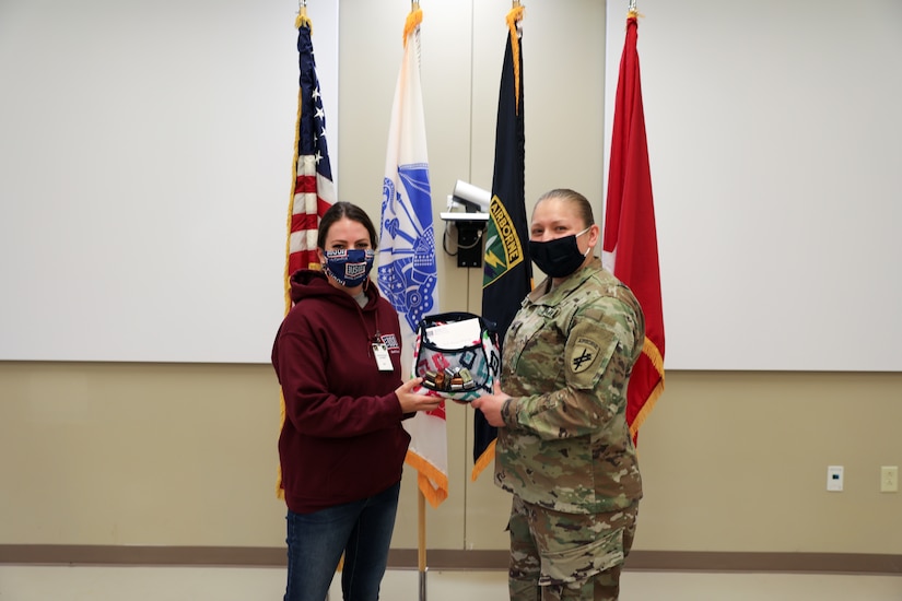 Shelby Rangel, Center Director for the Ft. Bragg USO, presents Sgt. Teresa Gonzalez, S1 NCOIC for the 1st Civil Affairs and Psychological Operations Training Brigade, with a USO sponsored gift bag. Gonzalez was nominated by her coworker, Ms. Kristen Bell, and recognized by the USO as one of thirty female servicemembers across Ft. Bragg to be honored during Women’s History month.