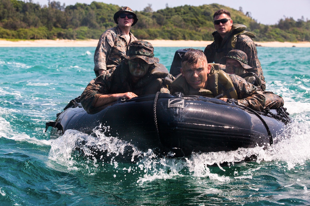 Marines ride in a small boat.