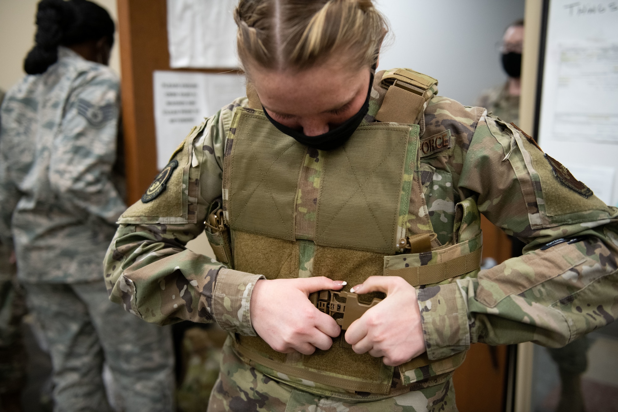 Airman Grace Bailey, a 28th Security Forces Squadron response force leader, clips on the Aspetto Mach V Female Body Armor (FBA) system for the first time at Ellsworth Air Force Base, S.D., March 2, 2021. The new armor aids in reducing injury and allows more flexibility with equipment carriage during combat operations. (U.S. Air Force photo by Staff Sgt. Hannah Malone)