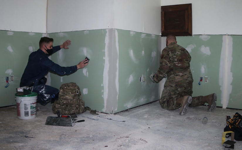 Airman Brody Yates, 628th Civil Engineer Squadron structural apprentice, left, sands drywall as Tech. Sgt. Jason Goss, 28th CES structural craftsman, right, puts joint compound on a wall at Dyess Air Force Base, Texas, Mar. 9, 2021. Members of U.S. Air Force CES’s maintain and repair all base facilities, conduct disaster preparedness training and manages all fire protection and prevention activities.