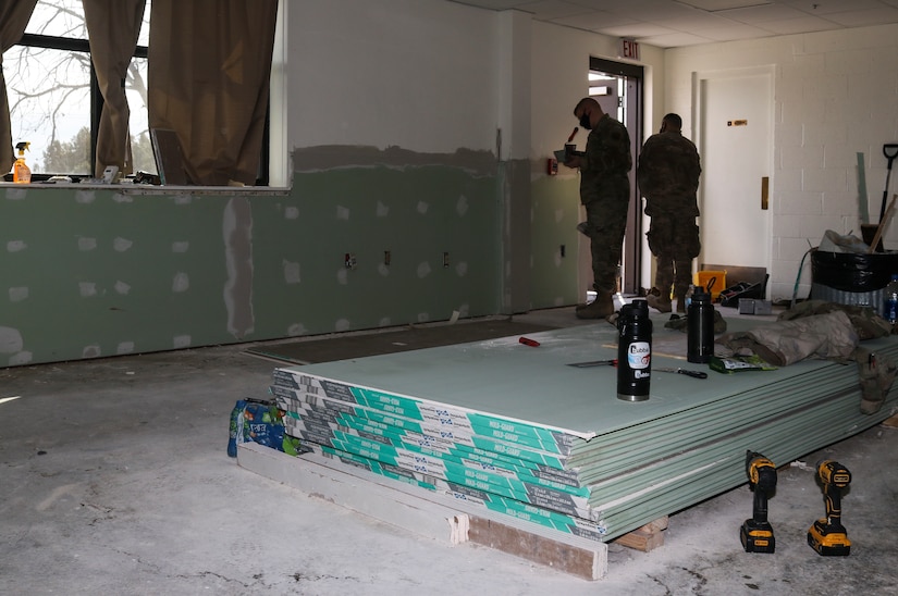 Civil Engineer Squadron members review joint compound work as they refurbish part of a building at Dyess Air Force Base, Texas, Mar. 9, 2021. Members of CES’s from Travis AFB, Calif., Charleston AFB, S.C., F.E. Warren AFB, Wyo., and Minot AFB, N.D., aided Dyess personnel with repairing a building affected by winter weather damage.