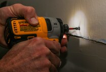 Tech. Sgt. Paul Rudolph, 5th Civil Engineer Squadron structural craftsman, secures joint compound and prepares the wall for a rail to bridge the gap between a wall at Dyess Air Force Base, Texas, Mar. 9, 2021. The CES Airmen also helped with plumbing and heating, ventilation and air conditioning unit support.