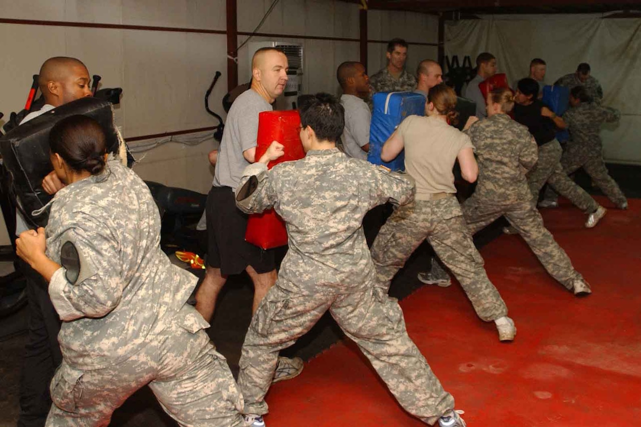 Female soldiers from the 1st Cavalry Division attack male soldiers holding pads after learning techniques in a women's self defense class. The class provided female soldiers with knowledge and experience on how to defend themselves in dangerous situations.