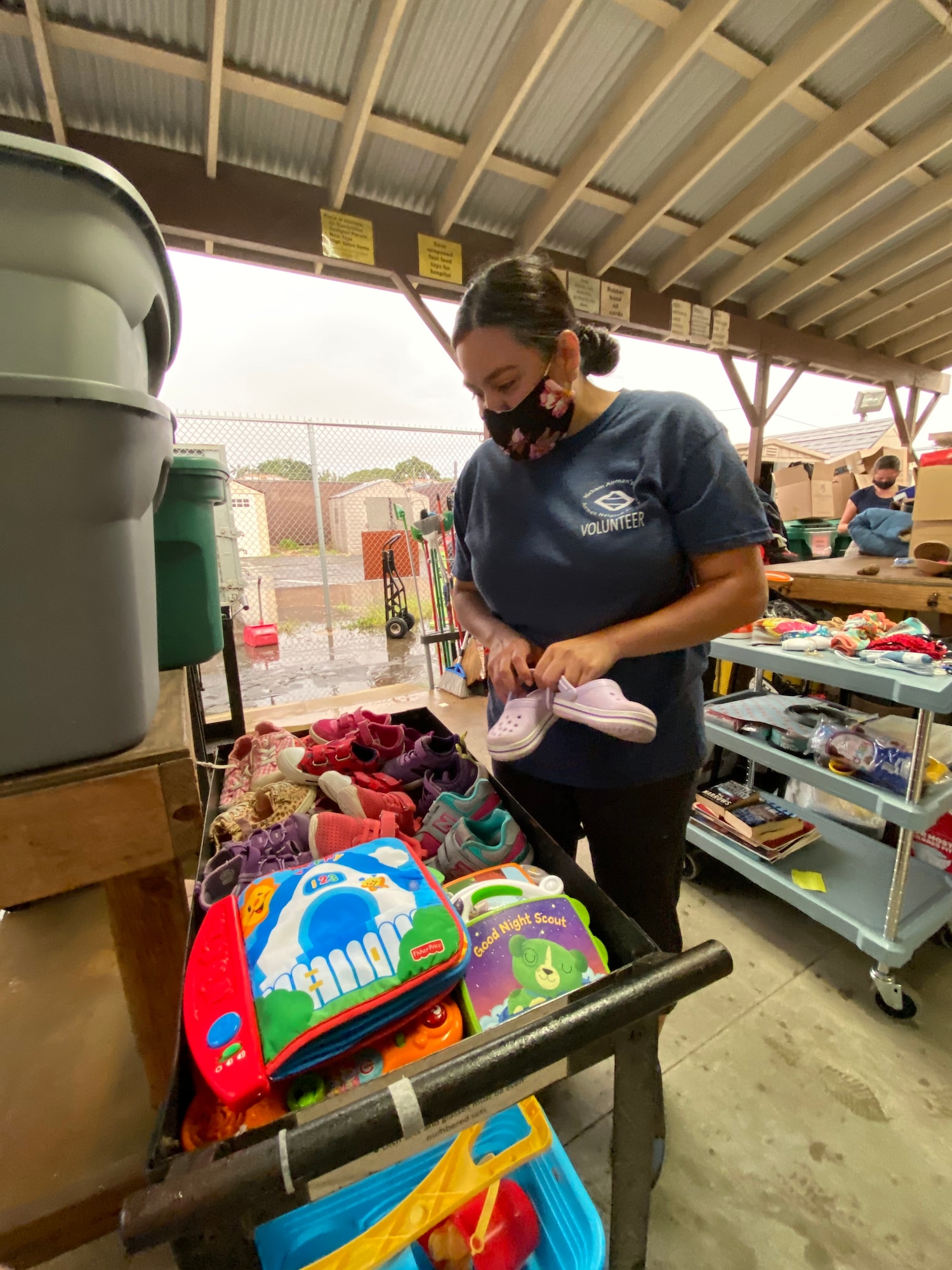 Patty Gonzalez, Hickam Airman’s Attic shift lead, sorts and displays donated clothing during a volunteer event at Joint Base Pearl Harbor-Hickam, Hawaii, March 10, 2021. The Airman’s Attic is a facility dedicated for junior enlisted airmen and their families to shop from a plethora of free donated goods ranging from baby supplies to military uniforms. (Courtesy Photo)