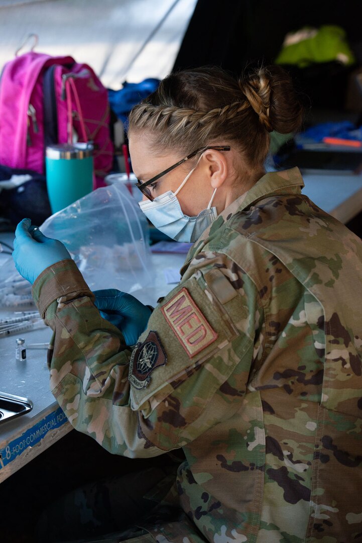 Senior Airman Erin Linhares, an aerospace medic with the 157th Medical Group, draws a dose of COVID-19 vaccine March 12, 2021, at the Exeter vaccination site.