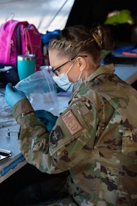 Senior Airman Erin Linhares, an aerospace medic with the 157th Medical Group, draws a dose of COVID-19 vaccine March 12, 2021, at the Exeter vaccination site.