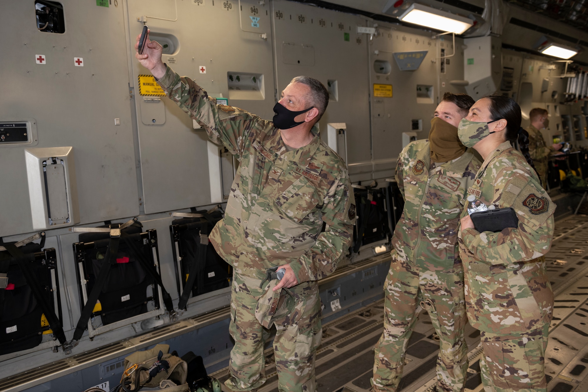 U.S. Air Force Col. Corey Simmons, left, 60th Air Mobility Wing commander, takes a selfie with Staff Sgt. Terry Durbin, center, 60th Aeromedical Evacuation Squadron unit training manager, and Capt. Erika Allen, 60th Aeromedical Evacuation Squadron flight examiner, during Leadership Rounds March 19, 2021, at Travis Air Force Base, California. The Leadership Rounds program provides 60th AMW leadership an opportunity to interact with Airmen and receive a detailed view of each mission performed at Travis AFB. (U.S. Air Force photo by Senior Airman Cameron Otte)
