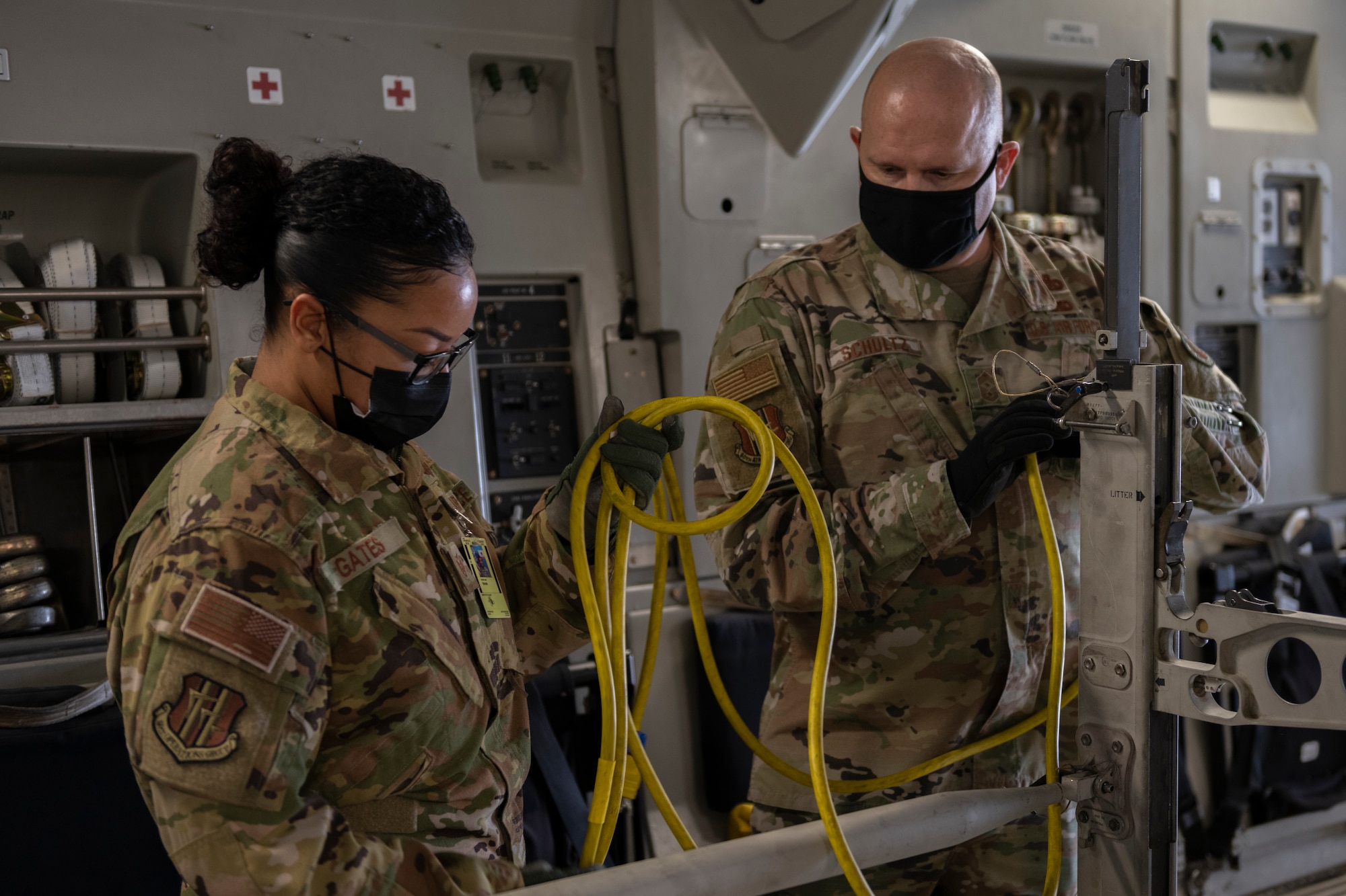 U.S. Air Force Staff Sgt. Jasmine Gates, left, 60th Aeromedical Evacuation Squadron flight instructor, shows Chief Master Sgt. Robert Schultz, 60th Air Mobility Wing command chief, how to perform a static mission during Leadership Rounds March 19, 2021, at Travis Air Force Base, California. The purpose of these static missions is to hone medical expertise and maintain mission readiness. The Leadership Rounds program provides 60th AMW leadership an opportunity to interact with Airmen and receive a detailed view of each mission performed at Travis AFB. (U.S. Air Force photo by Senior Airman Cameron Otte)