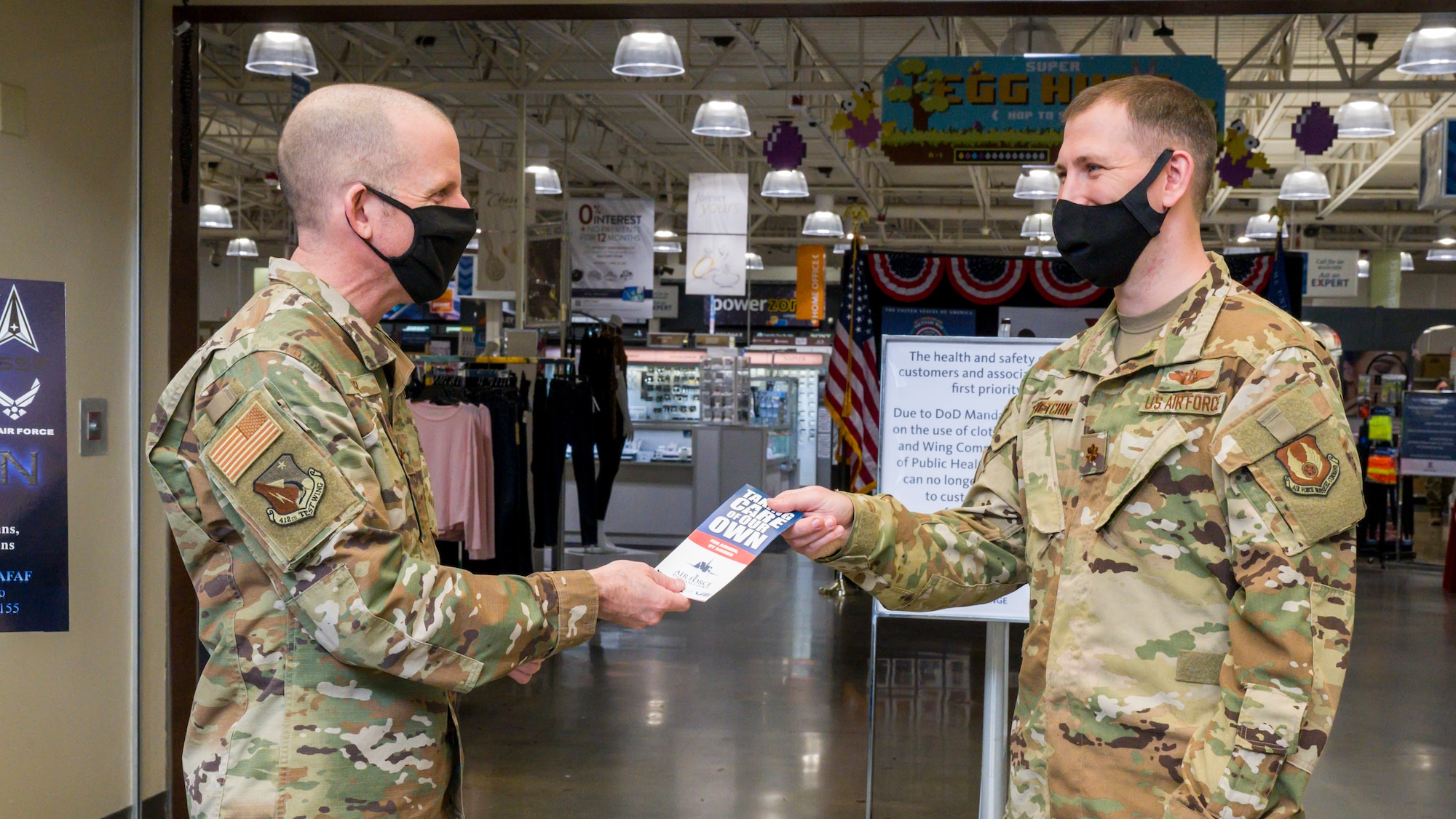 Brig. Gen. Matthew Higer, 412th Test Wing Commander, hands an Air Force Assistance Fund pamphlet to Maj. Peter Zevetchin, Air Force Materiel Command, at Edwards Air Force Base, California, March 22. (Air Force photo by Giancarlo Casem)