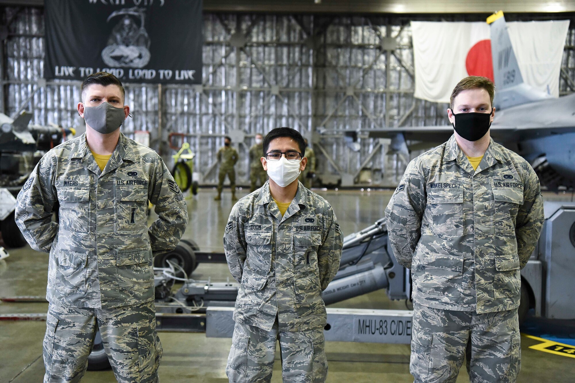 .S. Air Force Staff Sgt. Kevin Myers, a weapons load team chief, Senior Airman Victor Odom and Airman 1st Class Austin Winkelspecht, weapons load team members, all with the 14th Aircraft Maintanence Unit, stand in front of the F-16 Fighting Falcon they will equip in the fourth quarter load compitition at Misawa Air Base, Japan, March 19, 2021.