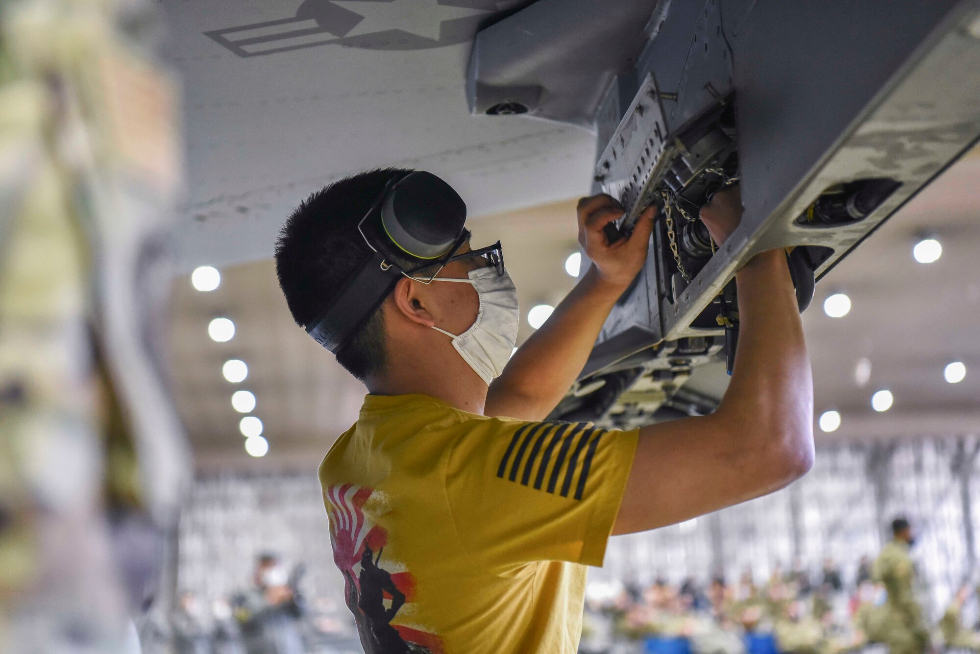 U.S. Air Force Senior Airman Victor Odom, a 14th Aircraft Maintance Unit weapons load crew member, opens up the F-16 Fighting Falcon's wing in order to load an AGM-158 joint air-to-surface standoff missile onto it during the fourth quartely load compitition at Misawa Air Base, Japan, March 19, 2021.