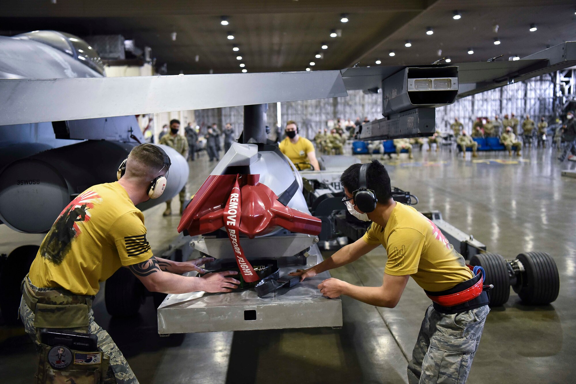 U.S. Air Force Staff Sgt. Kevin Myers, left, a weapons load team chief, and Senior Airman Victor Odom, right, a weapons load crew member, both with the 14th Aircraft Maintenance Unit, load an AGM-158 joint air-to-surface standoff missile onto a F-16 Fighting Falcon during the fourth quarter load competition at Misawa Air Base, Japan, March 19, 2021.