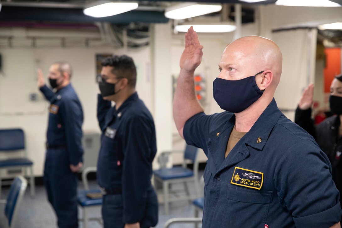 Chief Legalman Justin Hood, assigned to the aircraft carrier USS Gerald R. Ford (CVN 78), recites the oath of enlistment during an extremism standdown training.