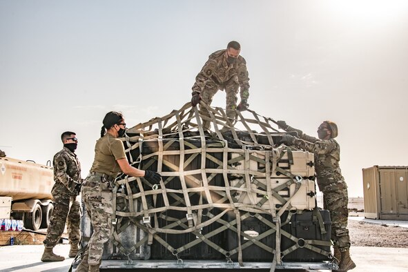 Airmen wrap cargo in straps