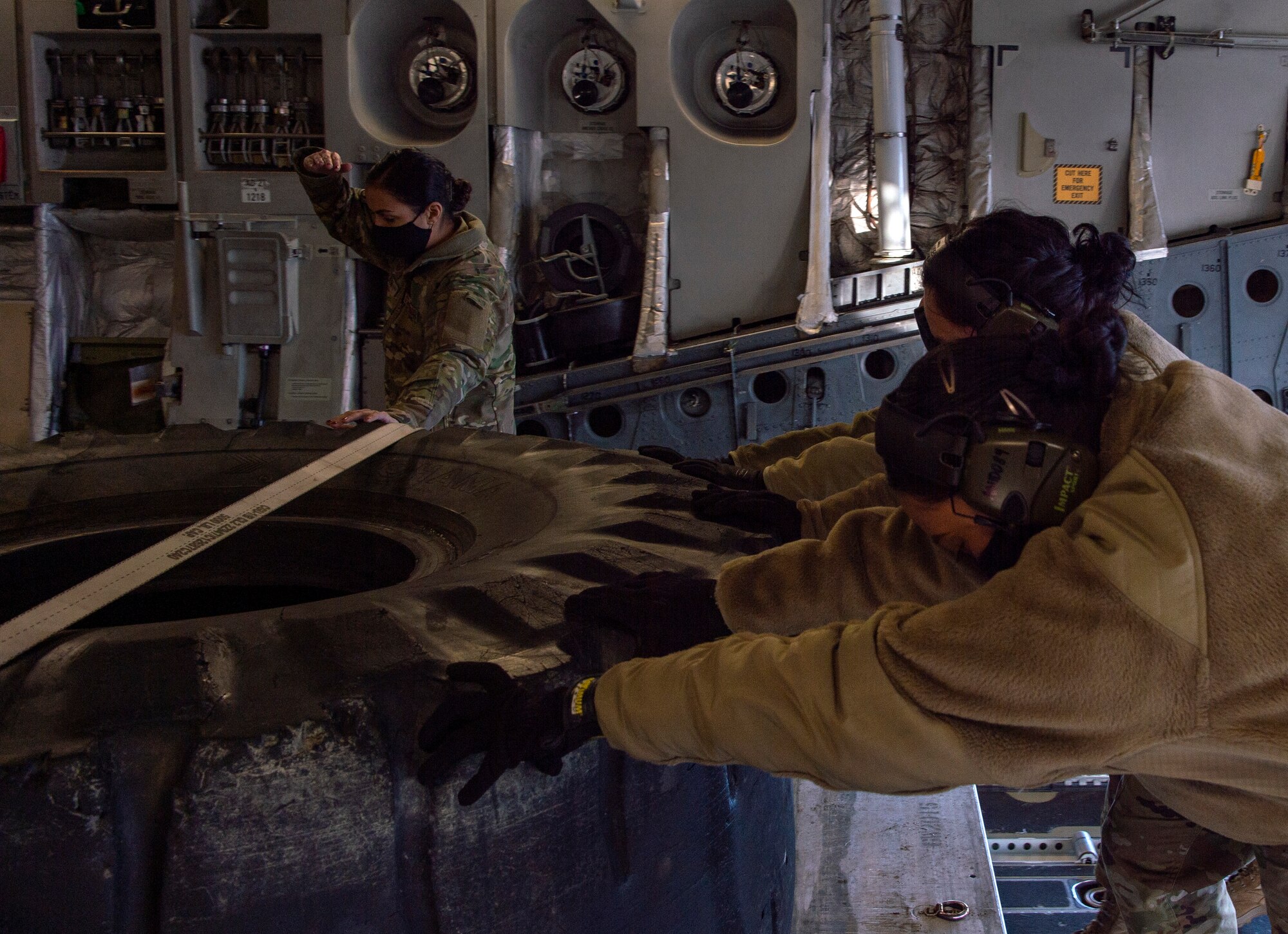 U.S. Air Force Tech. Sgt. Jaideep Kaur, left, 7th Airlift Squadron Operations Flight flight chief, alongside other 62nd Aerial Port Squadron Airmen, load a combat pallet onto a C-17 Globemaster III at Joint Base Lewis-McChord, Washington, Dec. 14, 2020. Kaur and other Team McChord Airmen comprised an all-female crew who prepared, launched and executed a flight-training mission. (U.S. Air Force photo by Senior Airman Tryphena Mayhugh)