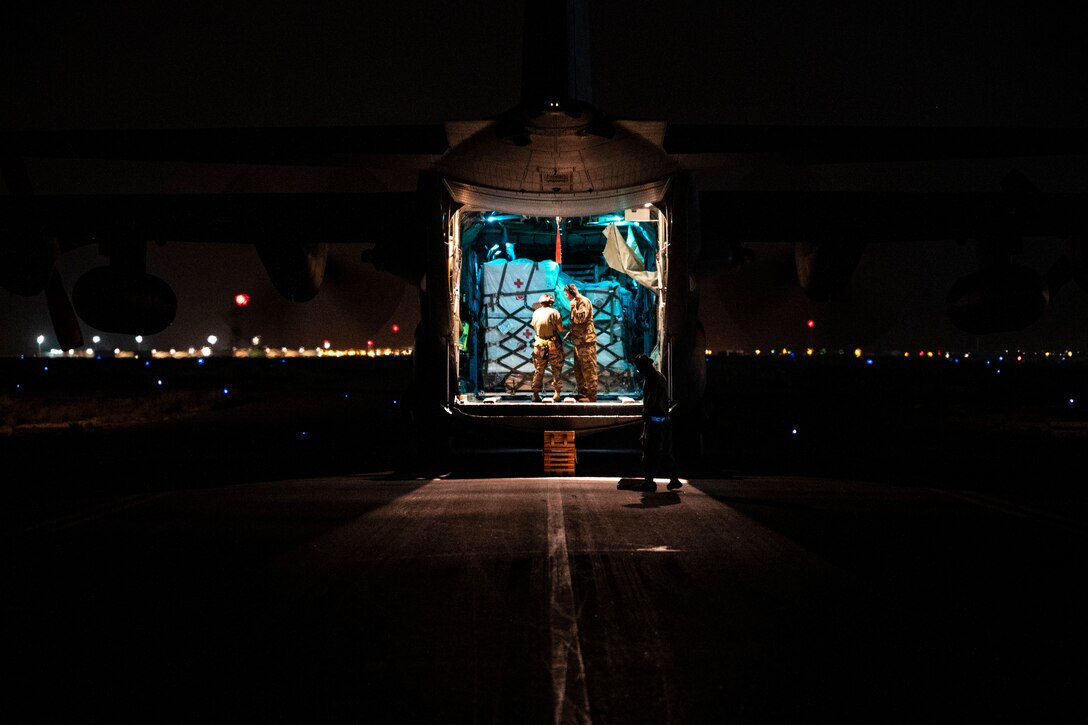 U.S. Airmen unload COVID-19 vaccines from a C-130 Hercules at Al Dhafra Air Base, United Arab Emirates, March 15, 2021. Approximately 1,300 single-shot vaccine doses were sent to the base ready to distribute among service members and Defense Department personnel at the installation.