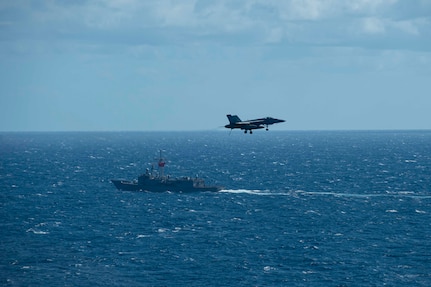 The Turkish frigate TCG Gemlik (F 492) sails alongside the Nimitz-class aircraft carrier USS Dwight D. Eisenhower (CVN 69) during flight operations in the Mediterranean Sea.