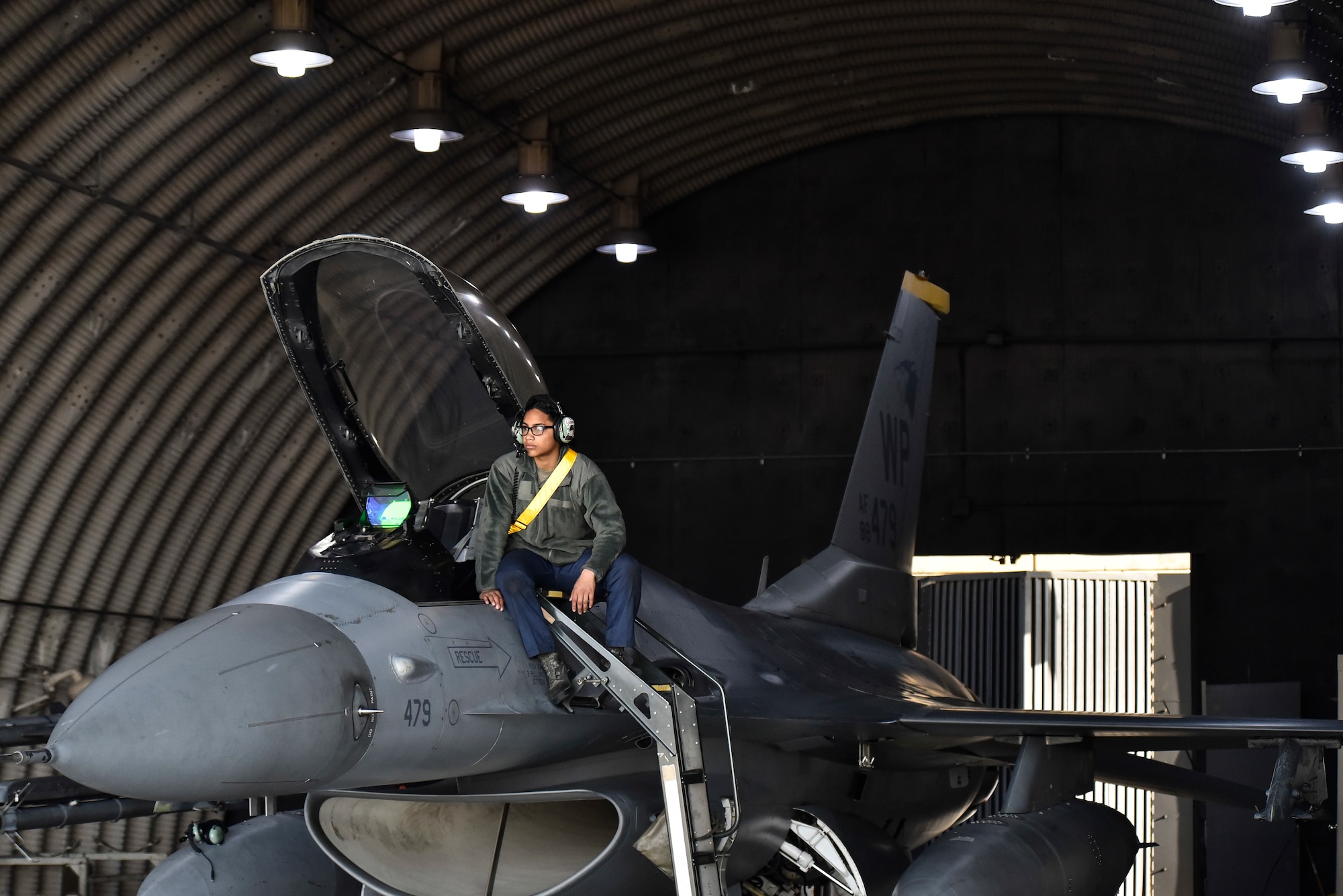 A crew chief sits on an F-16.