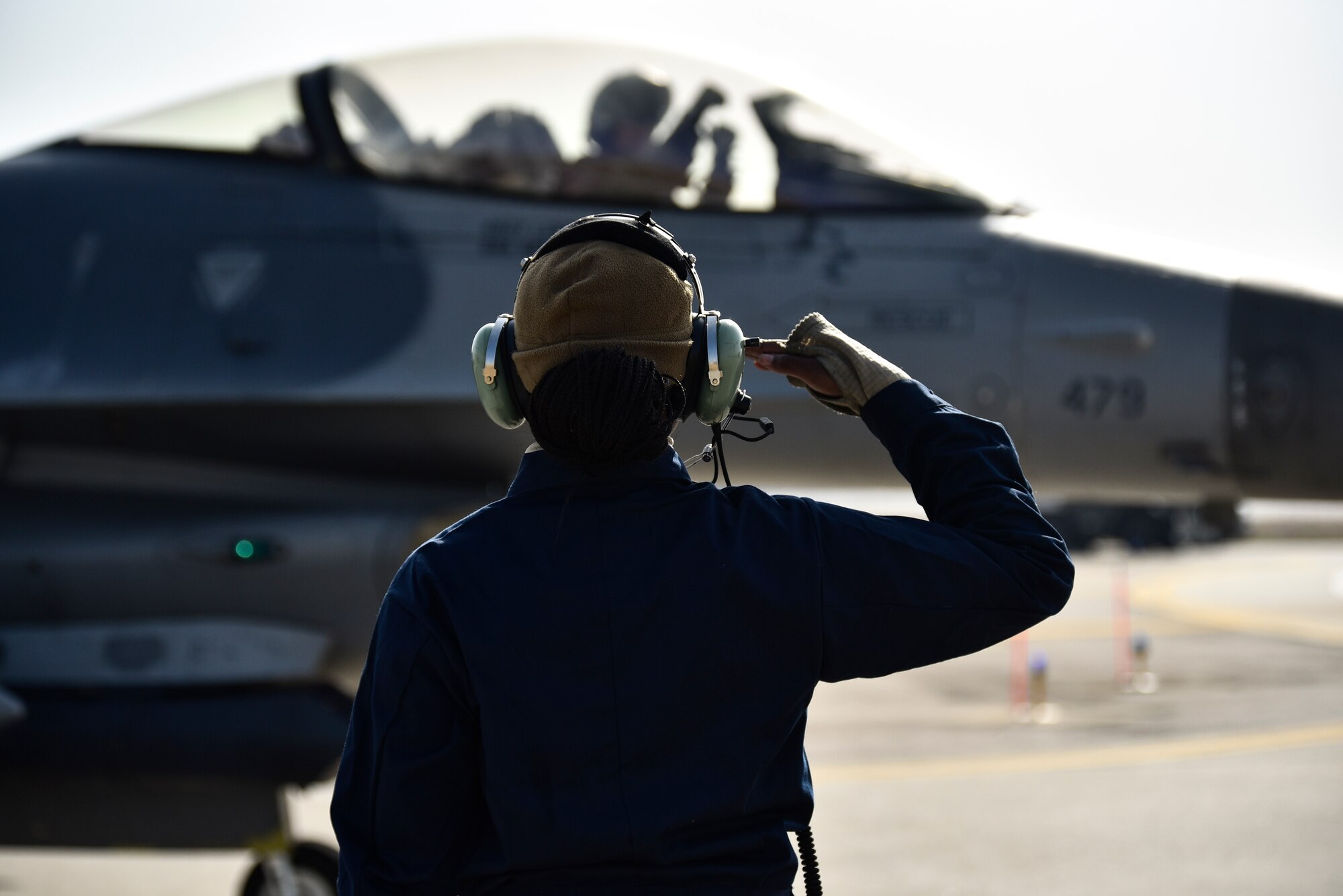 A crew chief salutes a pilot.